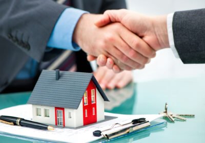 Estate agent shaking hands with customer after contract signature